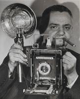 圖片1. 維加（Weegee）個人照，手拿著因他的使用而在當時大受流行的媒體相機（press camera / speed graphic camera）, Courtesy of Internati